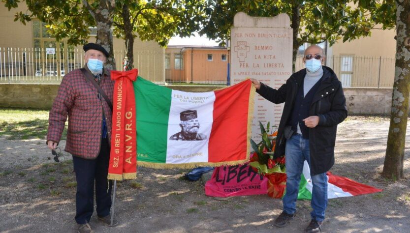 Nella foto: Gianfranco Paris e Gino Martellucci con bandiera dell’ANVRG alla commemorazione delle Fosse Reatine (foto Massimo Renzi)